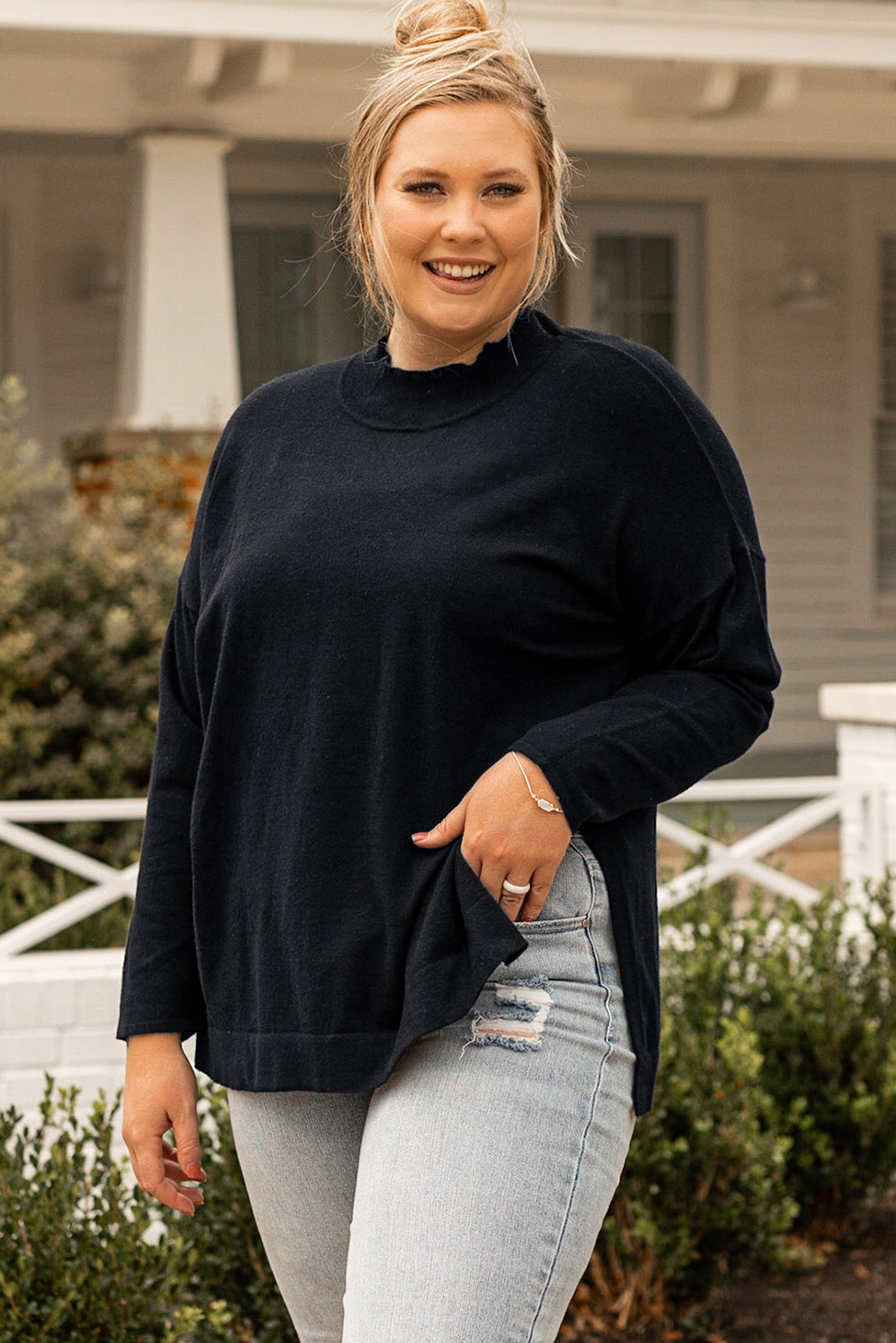 Black plus size loose sweater with side slits and high neck design, showcasing a relaxed fit and stylish look.