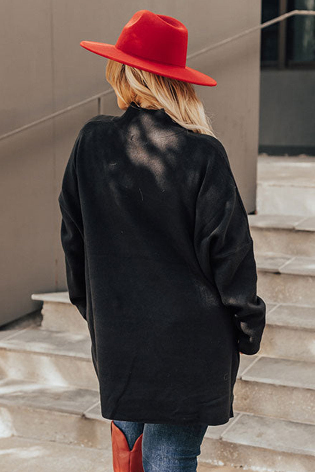 Black plus size loose sweater with side slits and high neck design, showcasing a relaxed fit and stylish look.