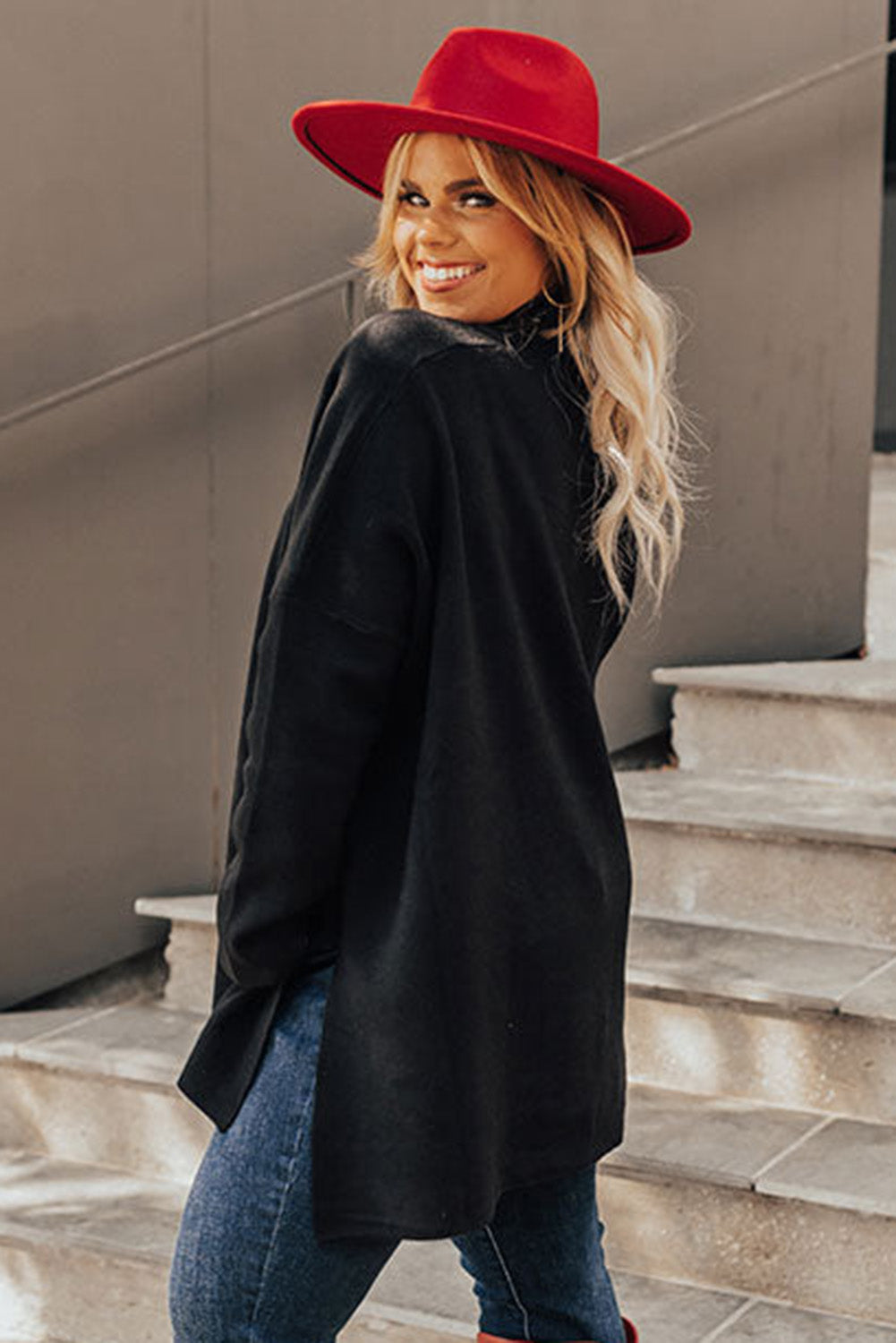 Black plus size loose sweater with side slits and high neck design, showcasing a relaxed fit and stylish look.