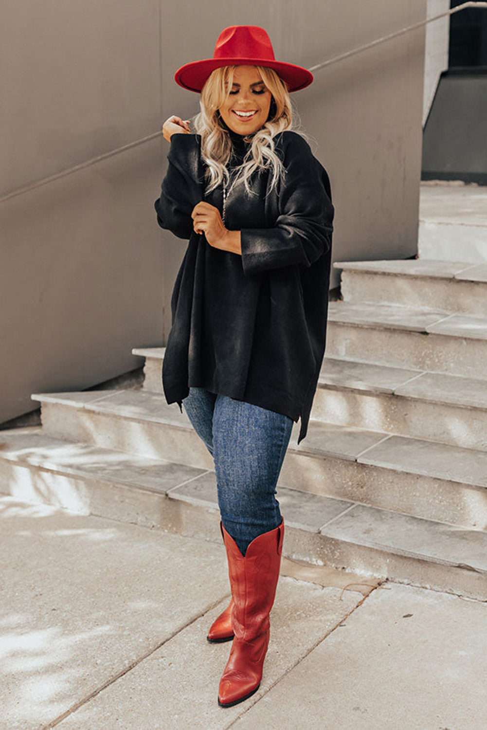 Black plus size loose sweater with side slits and high neck design, showcasing a relaxed fit and stylish look.