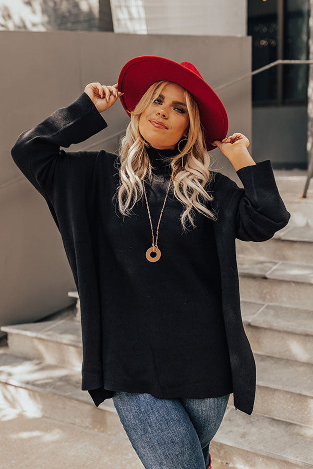 Black plus size loose sweater with side slits and high neck design, showcasing a relaxed fit and stylish look.