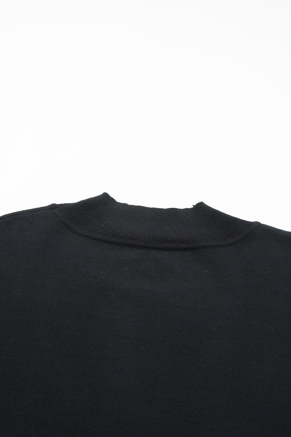 Black plus size loose sweater with side slits and high neck design, showcasing a relaxed fit and stylish look.