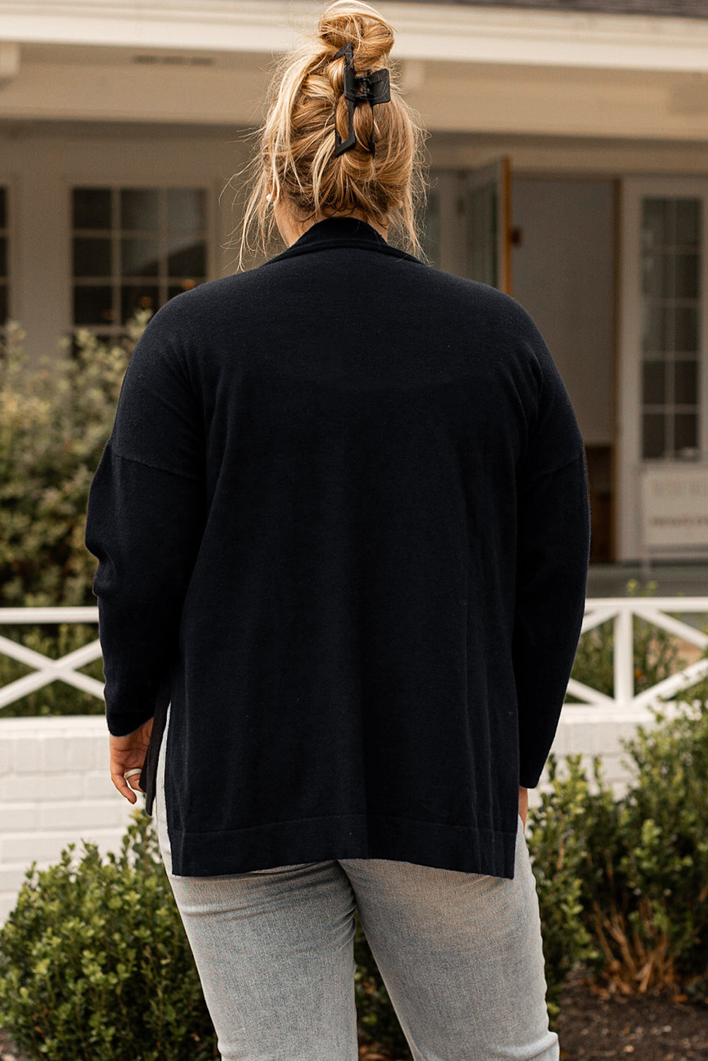 Black plus size loose sweater with side slits and high neck design, showcasing a relaxed fit and stylish look.
