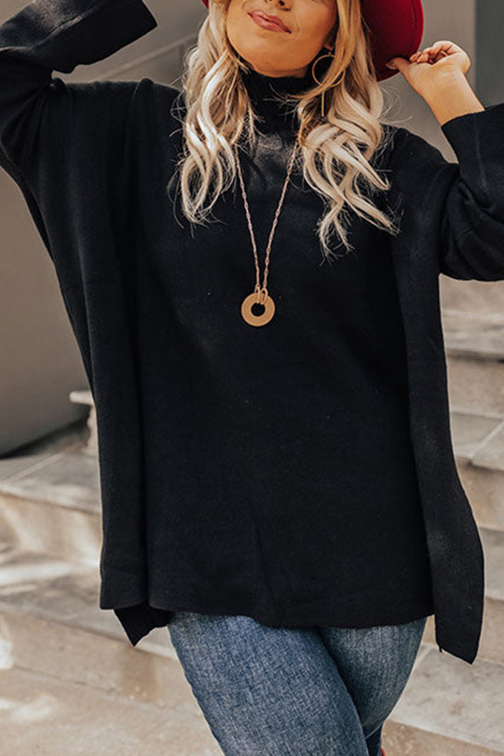 Black plus size loose sweater with side slits and high neck design, showcasing a relaxed fit and stylish look.