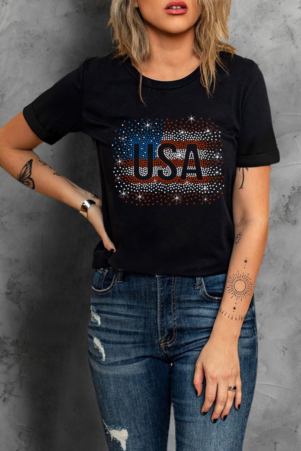 Black t-shirt featuring a rhinestone graphic of the American flag, showcasing a stylish patriotic design.
