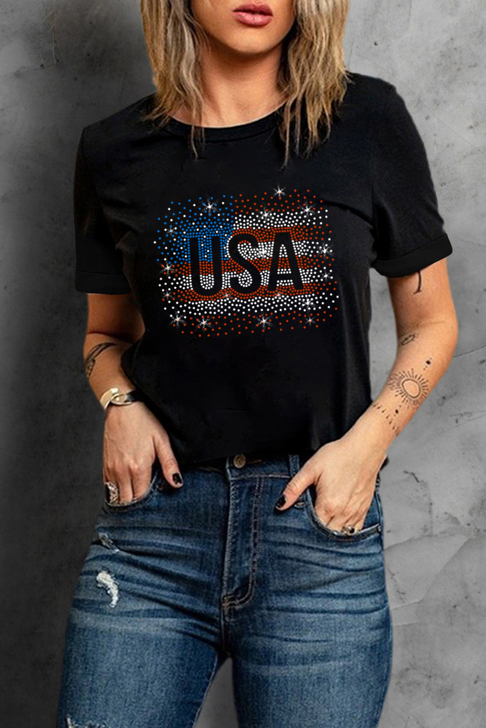 Black t-shirt featuring a rhinestone graphic of the American flag, showcasing a stylish patriotic design.