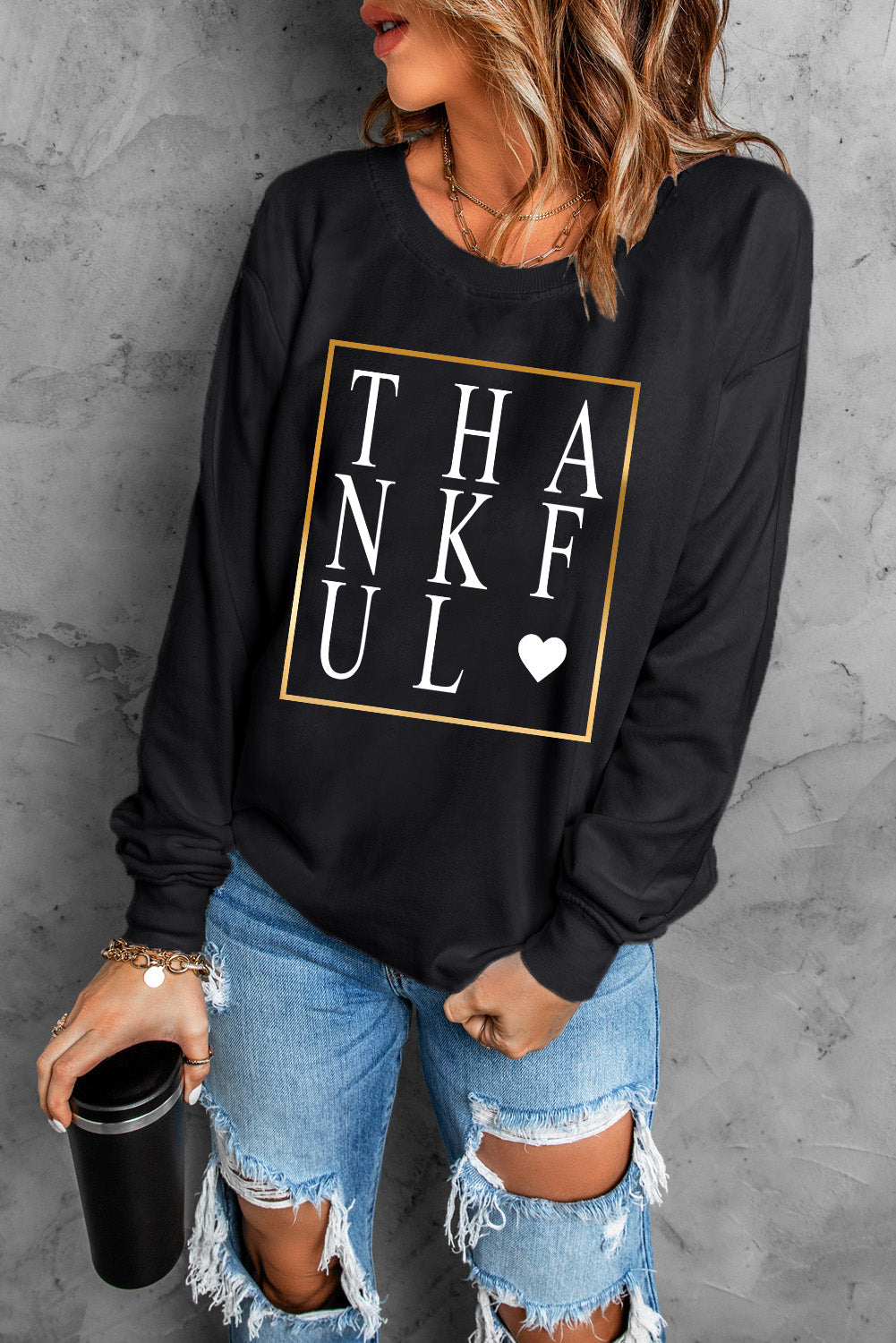 Black long sleeve sweatshirt featuring a heart print with the word 'THANKFUL' in stylish typography.
