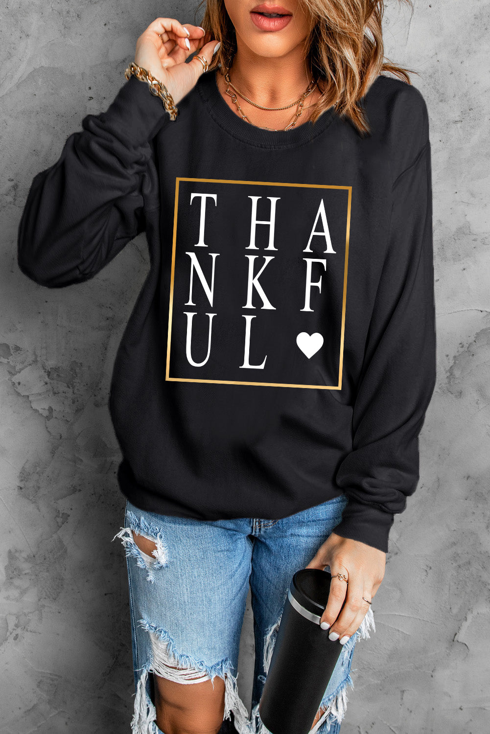 Black long sleeve sweatshirt featuring a heart print with the word 'THANKFUL' in stylish typography.