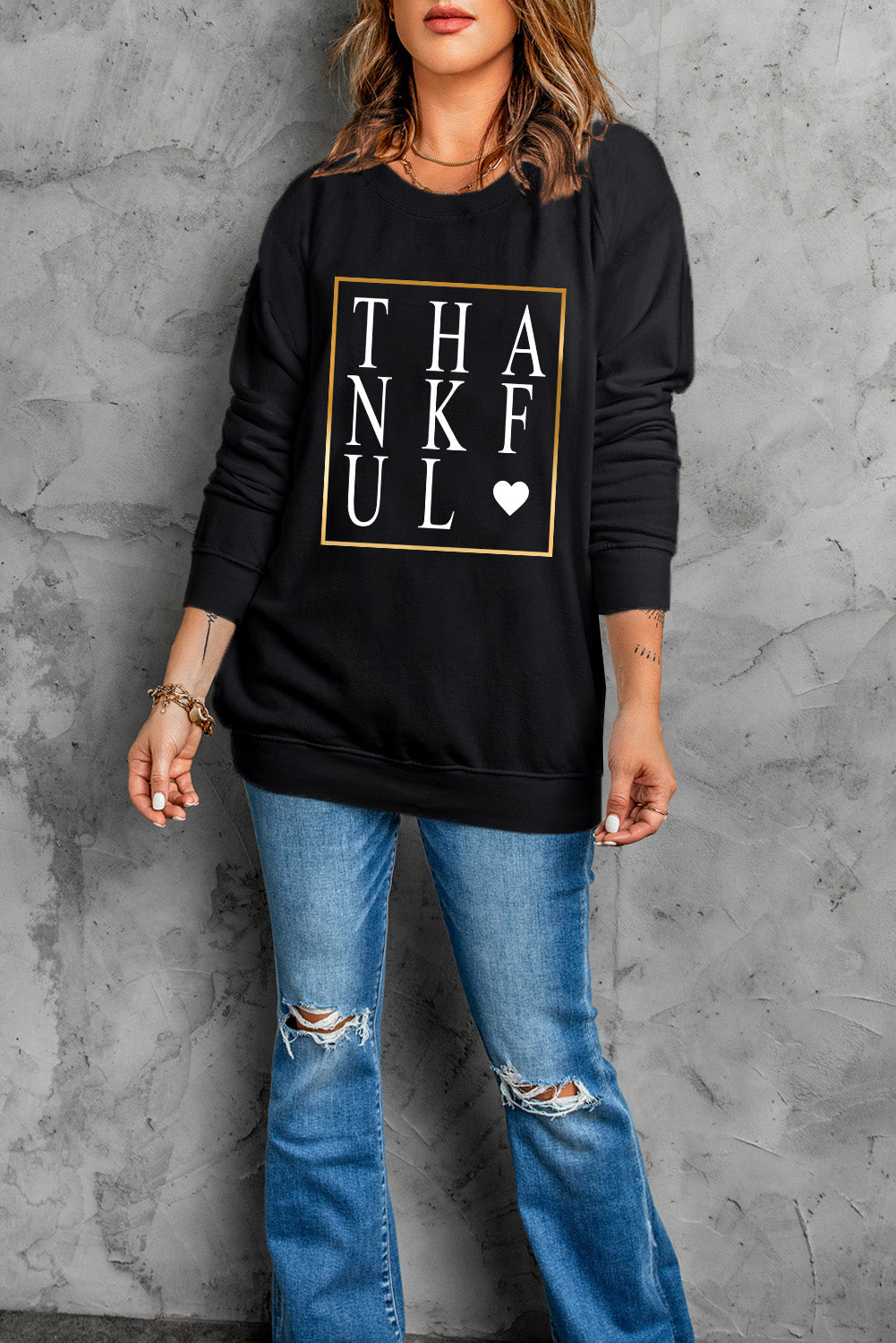 Black long sleeve sweatshirt featuring a heart print with the word 'THANKFUL' in stylish typography.