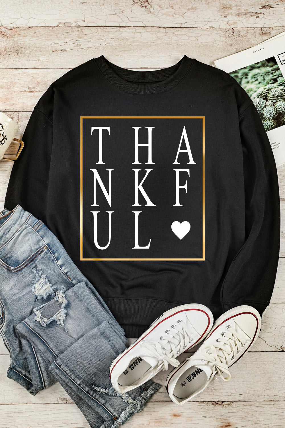 Black long sleeve sweatshirt featuring a heart print with the word 'THANKFUL' in stylish typography.