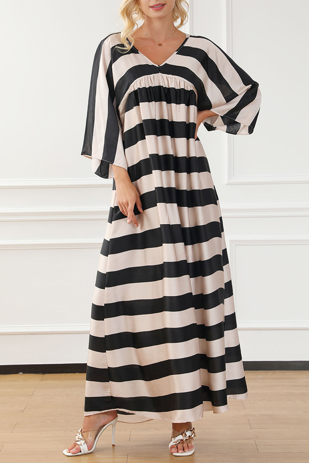 A stylish black maxi dress featuring a v neck and kimono sleeves, adorned with a classic striped print, perfect for elegant occasions.
