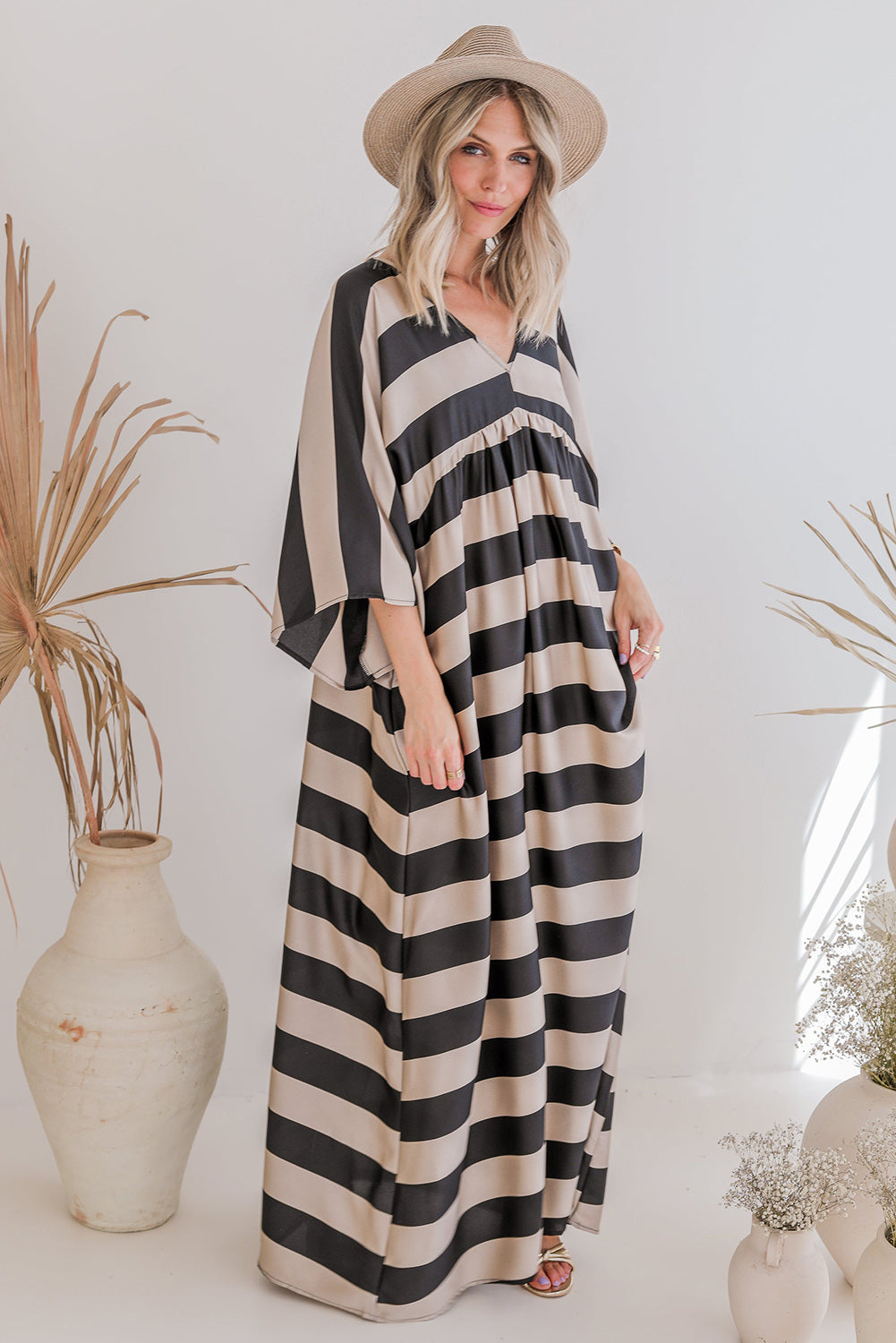 A stylish black maxi dress featuring a v neck and kimono sleeves, adorned with a classic striped print, perfect for elegant occasions.