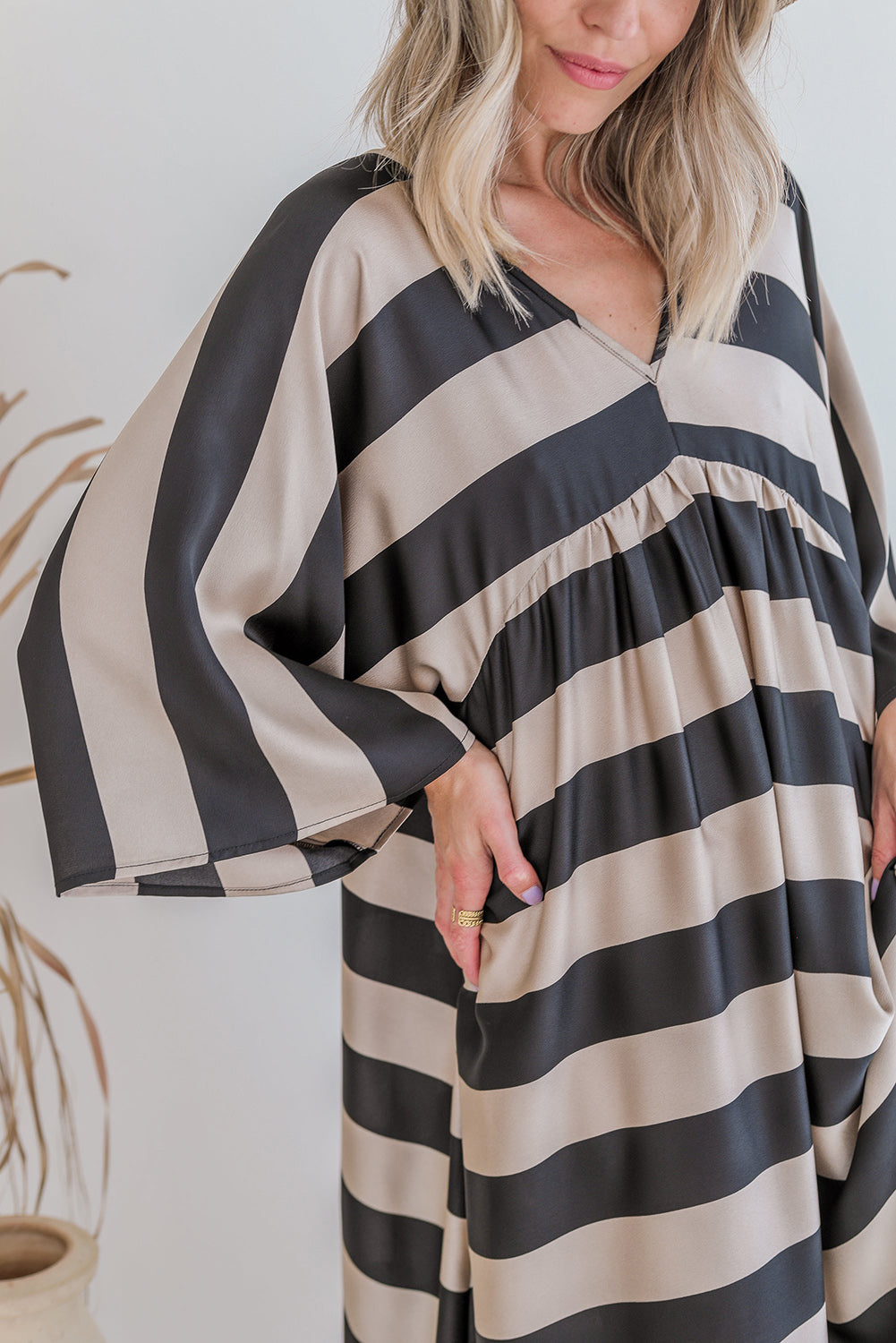 A stylish black maxi dress featuring a v neck and kimono sleeves, adorned with a classic striped print, perfect for elegant occasions.