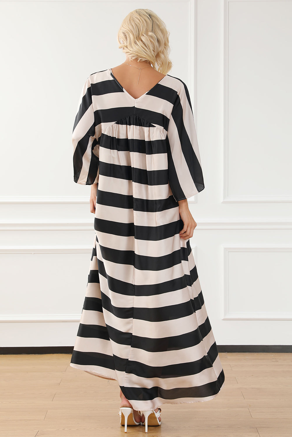 A stylish black maxi dress featuring a v neck and kimono sleeves, adorned with a classic striped print, perfect for elegant occasions.