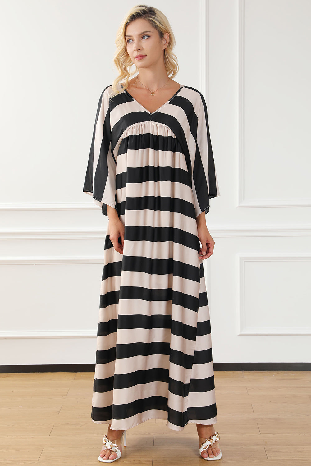 A stylish black maxi dress featuring a v neck and kimono sleeves, adorned with a classic striped print, perfect for elegant occasions.