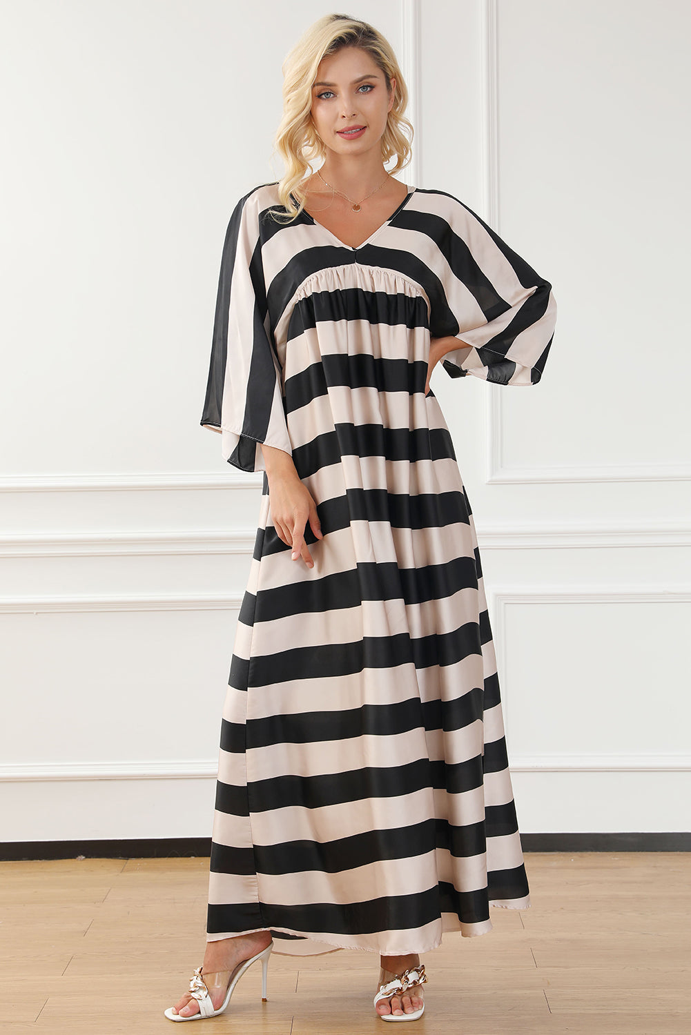 A stylish black maxi dress featuring a v neck and kimono sleeves, adorned with a classic striped print, perfect for elegant occasions.