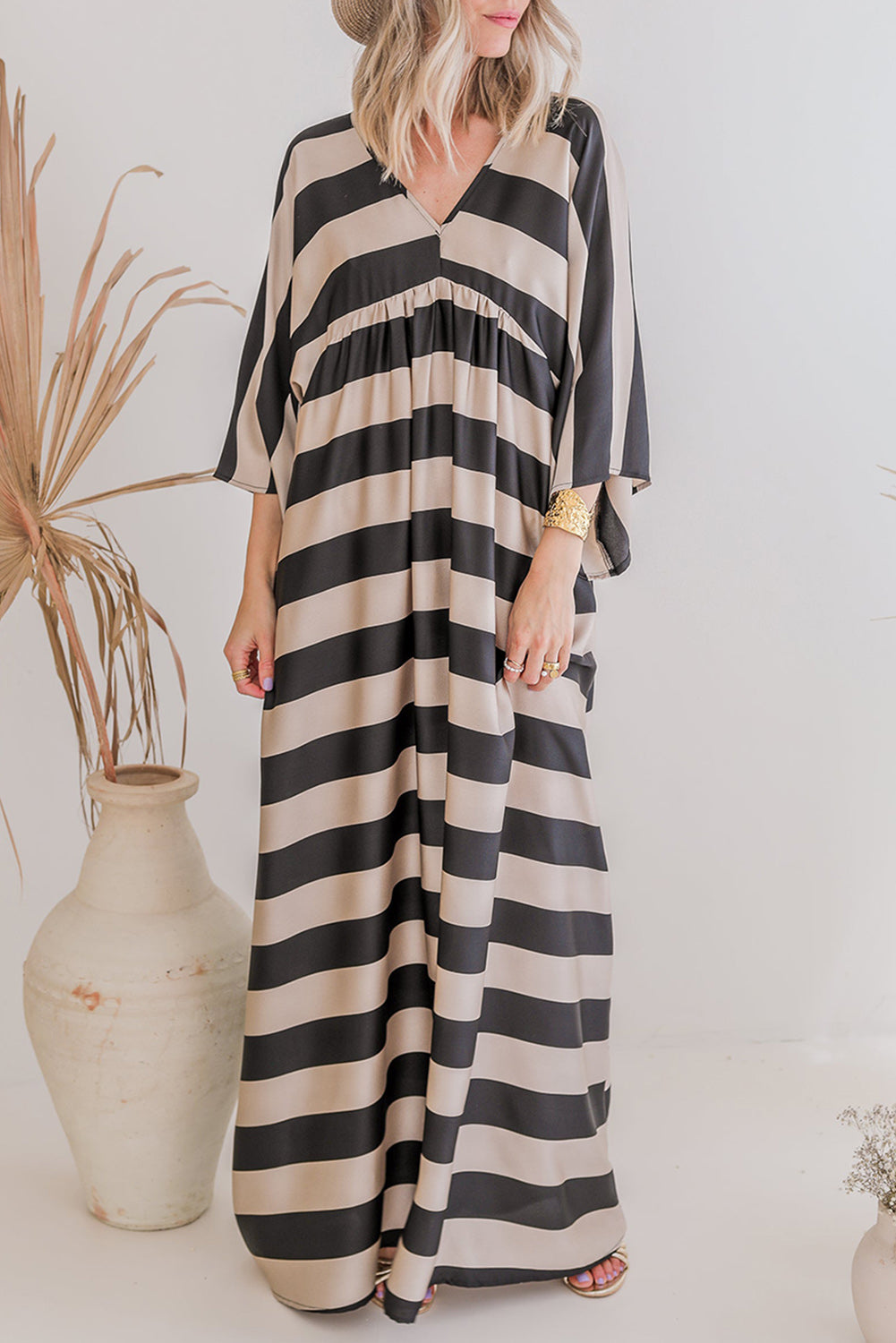 A stylish black maxi dress featuring a v neck and kimono sleeves, adorned with a classic striped print, perfect for elegant occasions.