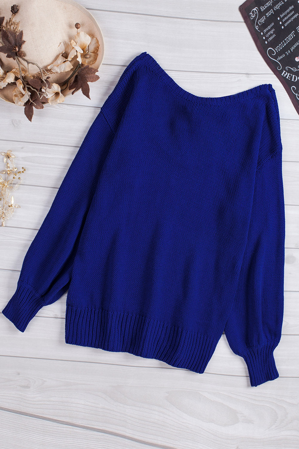 Blue drop shoulder sweater featuring a back cut-out and tie detail, showcasing a stylish and elegant design.