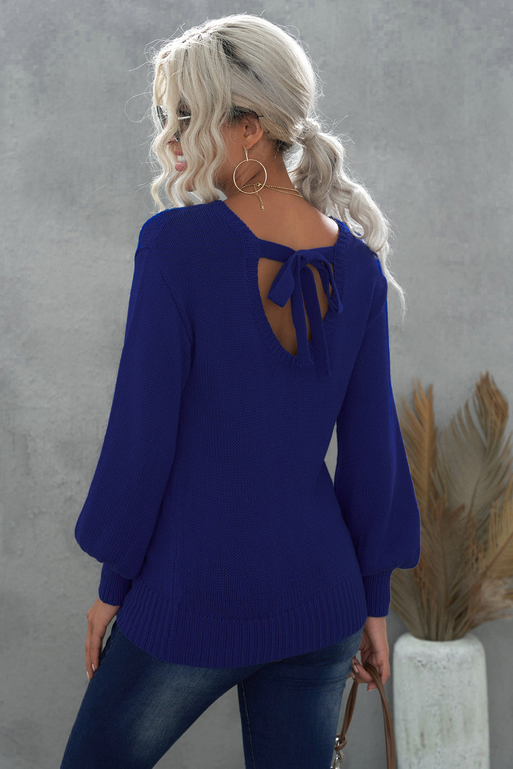 Blue drop shoulder sweater featuring a back cut-out and tie detail, showcasing a stylish and elegant design.