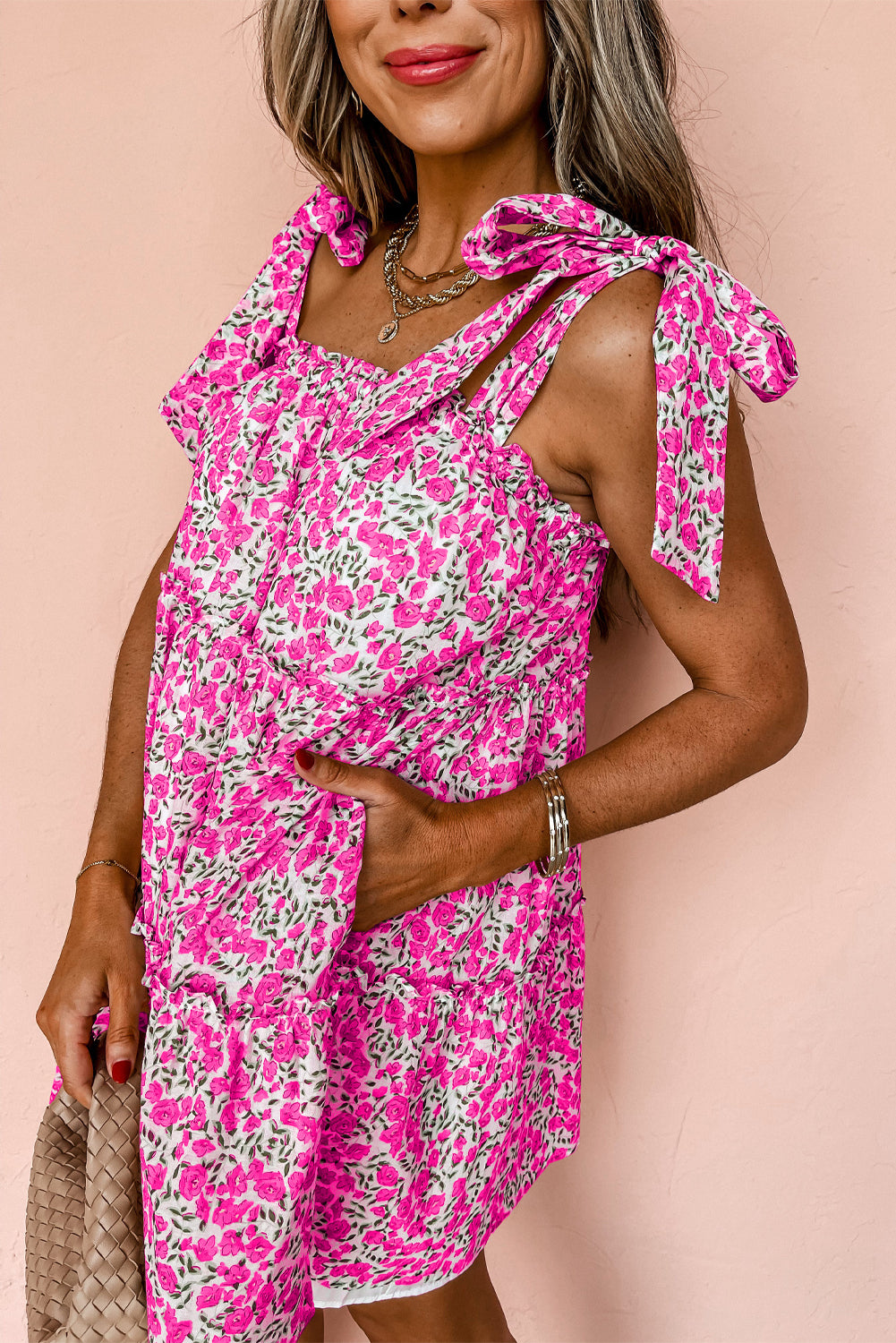 A stylish blue floral knotted straps tiered babydoll dress displayed on a mannequin, showcasing its elegant design and vibrant colors.