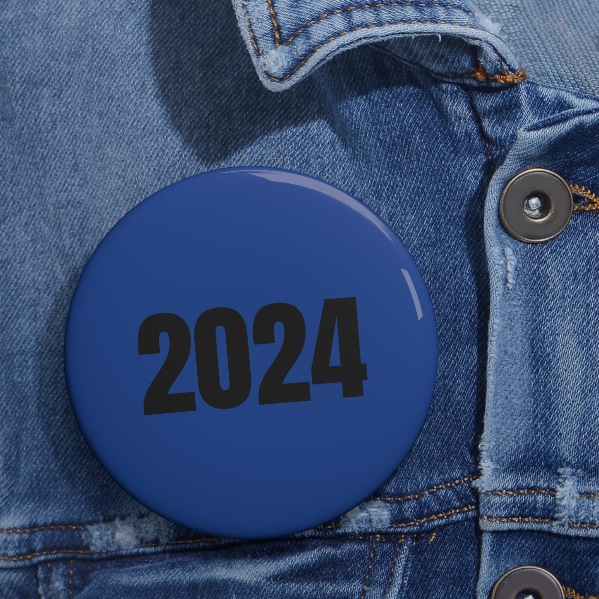 A collection of Blue Pin Buttons in various sizes, showcasing their glossy finish and safety pin backing.