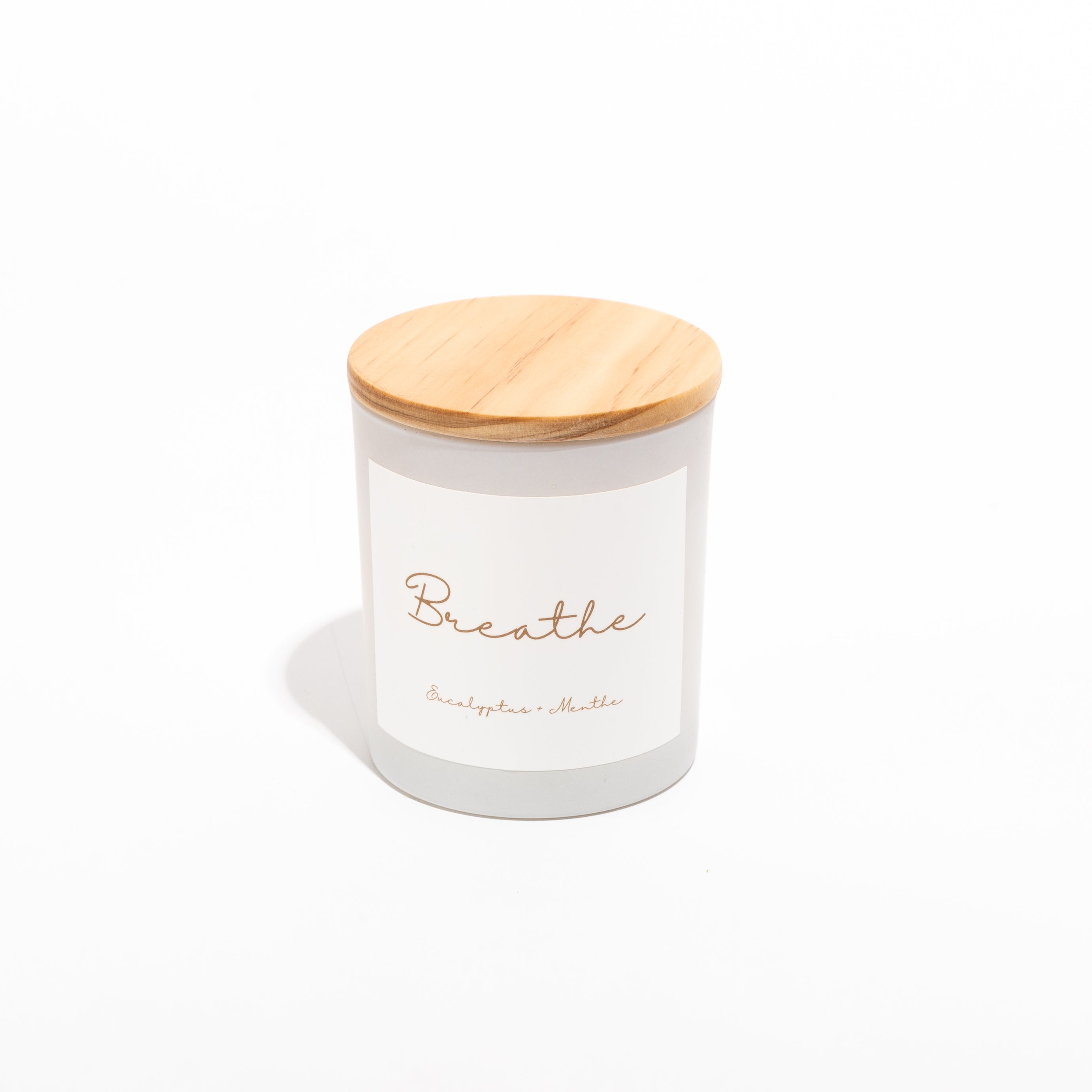 BREATHE candle in a glass jar with wooden lid, featuring eucalyptus and mint scent, showcasing a clean and elegant design.