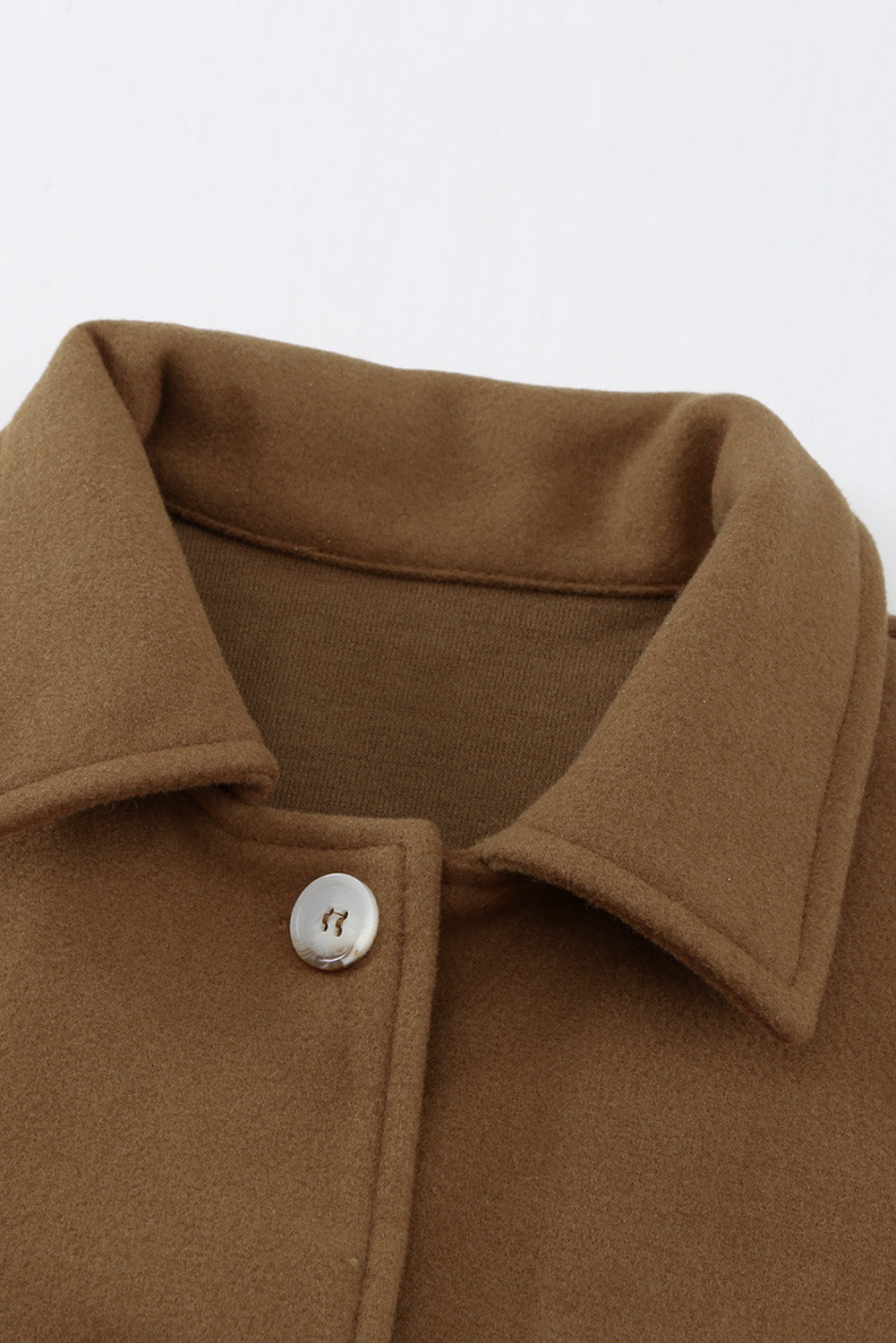 A stylish brown coat featuring a turn down collar, buttoned closure, and flap pockets, designed for a baggy fit.