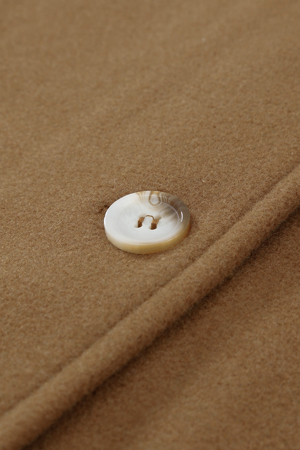 A stylish brown coat featuring a turn down collar, buttoned closure, and flap pockets, designed for a baggy fit.