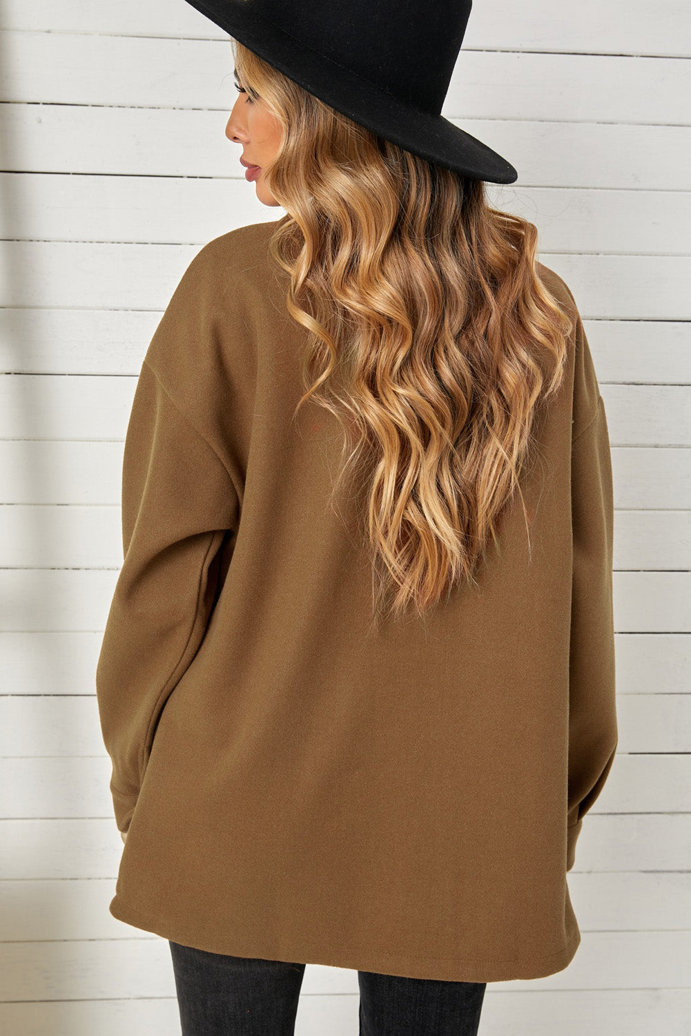 A stylish brown coat featuring a turn down collar, buttoned closure, and flap pockets, designed for a baggy fit.