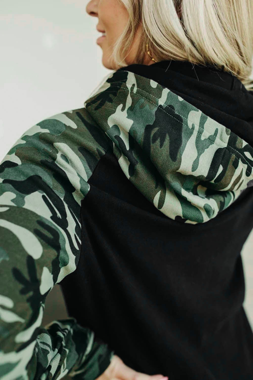 A stylish camouflage print raglan sleeve hoodie featuring a double hood and thumb holes, perfect for modern ladies in fall.