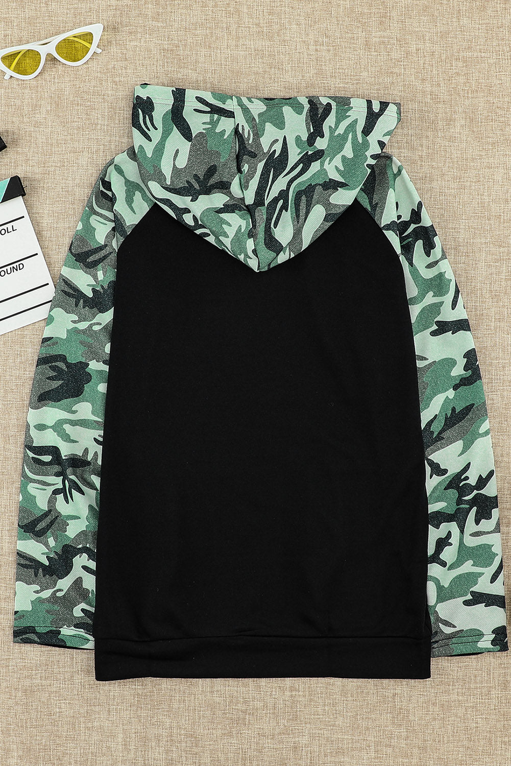 A stylish camouflage print raglan sleeve hoodie featuring a double hood and thumb holes, perfect for modern ladies in fall.