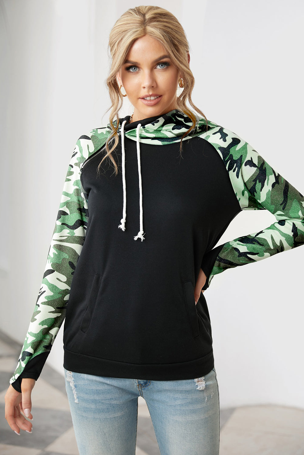 A stylish camouflage print raglan sleeve hoodie featuring a double hood and thumb holes, perfect for modern ladies in fall.