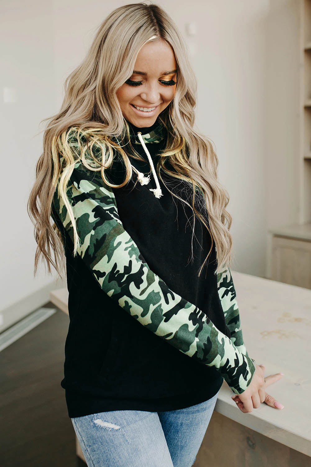 A stylish camouflage print raglan sleeve hoodie featuring a double hood and thumb holes, perfect for modern ladies in fall.