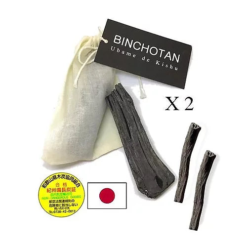 Deux morceaux de Charbon Végétal Binchotan Japonais de Kishu, de couleur noire, mesurant environ 2cm x 7cm, présentés sur un fond neutre.