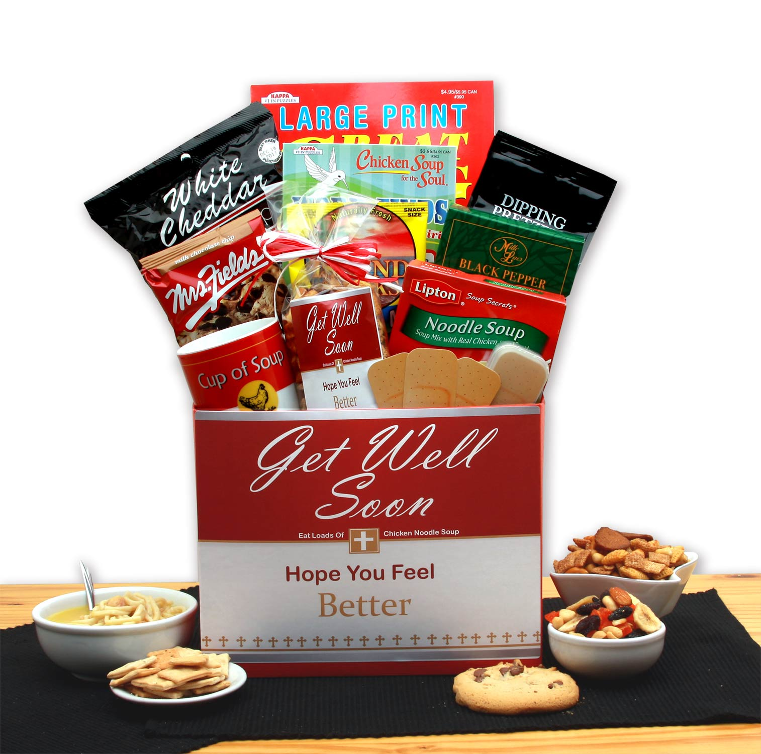 A beautifully arranged Chicken Noodle Soup Get Well Gift Box featuring soup mix, cookies, snacks, and puzzle books, wrapped in cellophane with a bow.