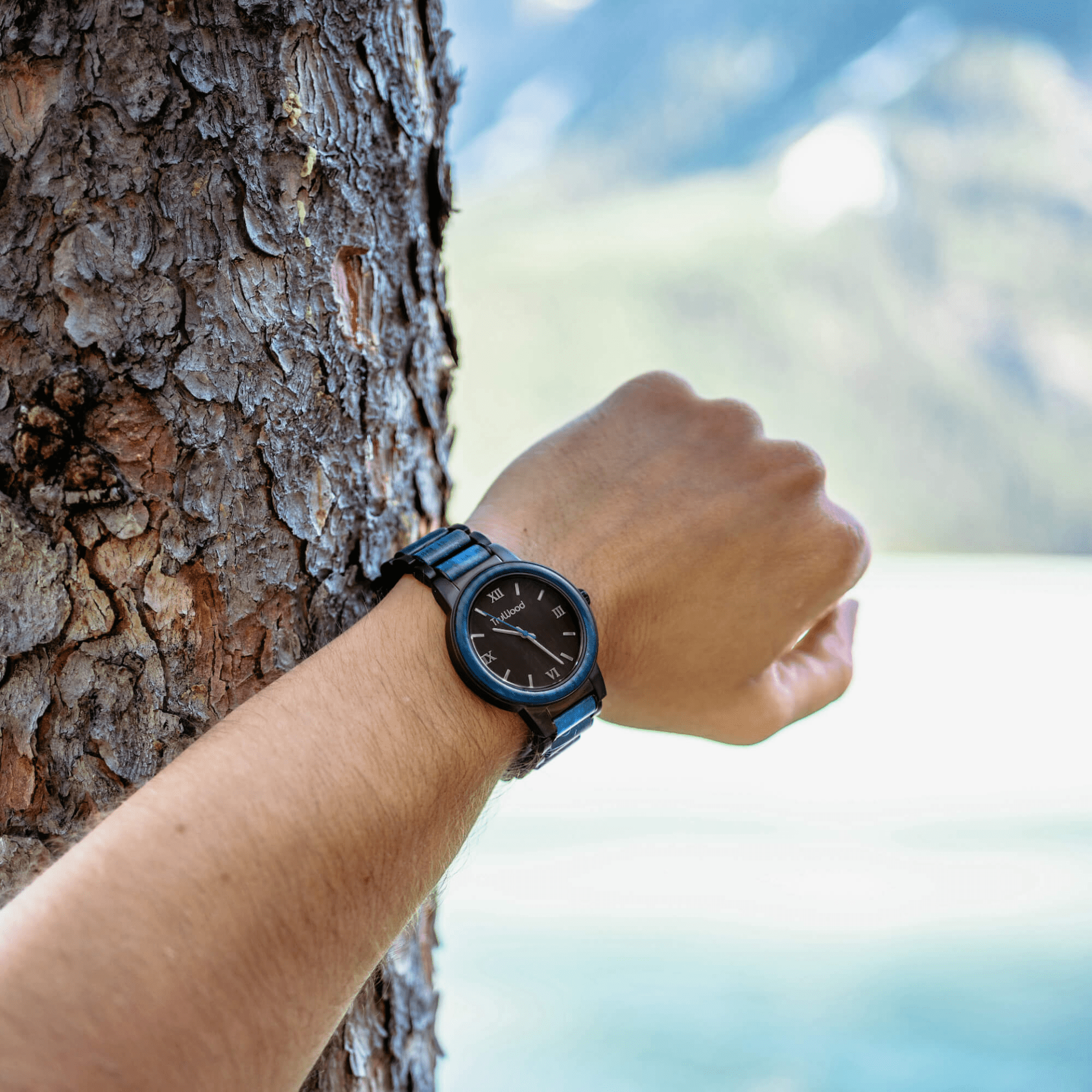 Coast Men's Watch featuring a stainless steel case, blue dyed maple wood bezel, and black sandalwood dial, showcasing its elegant design.