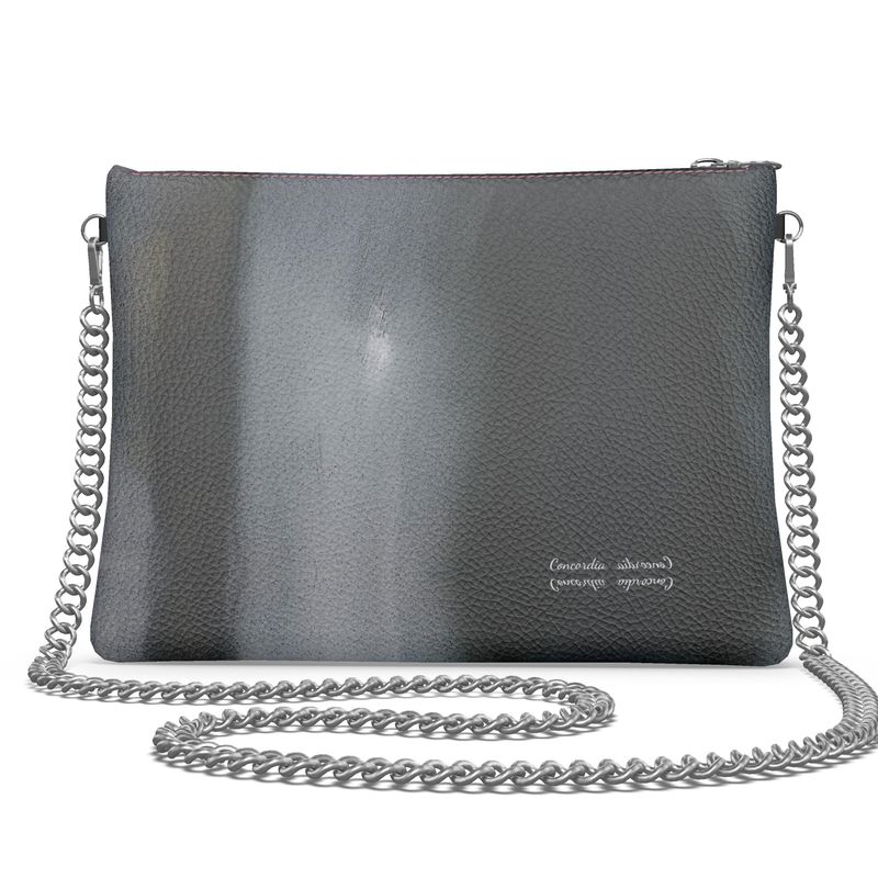 Stylish crossbody bag with a detachable chain strap and round metal zip pull, showcasing its unique design and craftsmanship.