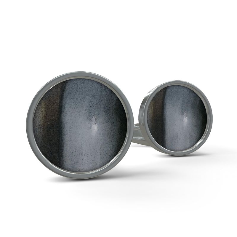 A pair of elegant silver designer cufflinks in a gift box, showcasing a unique hand-printed design.