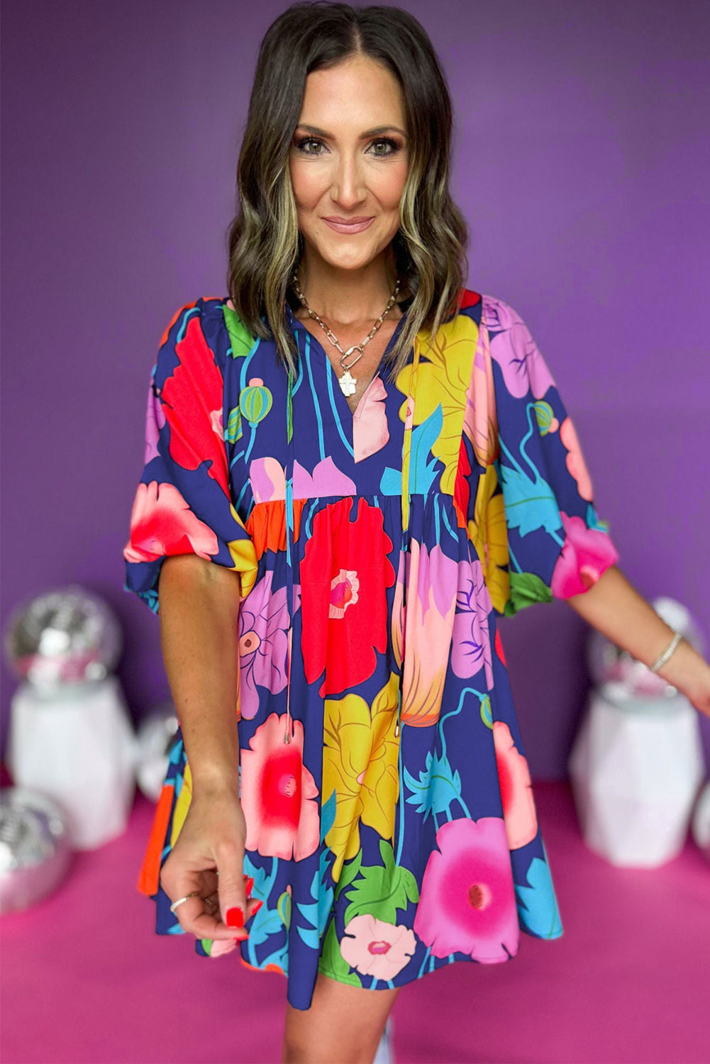 Dark blue floral print babydoll dress with split neck design, showcasing a feminine silhouette and vibrant floral patterns.