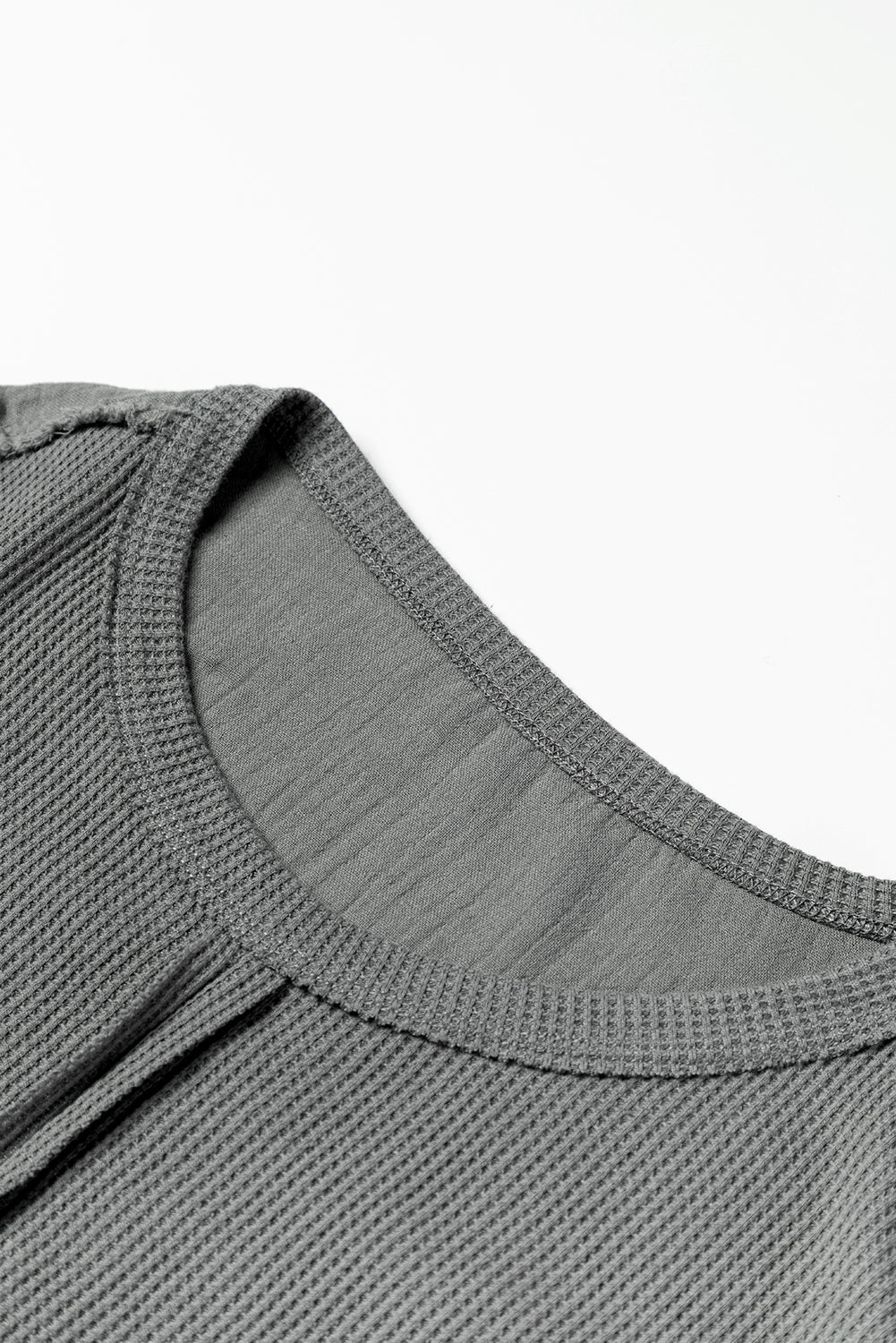 Dark brown waffle knit top with exposed seams and bubble sleeves, featuring a chic patchwork design and front pocket.