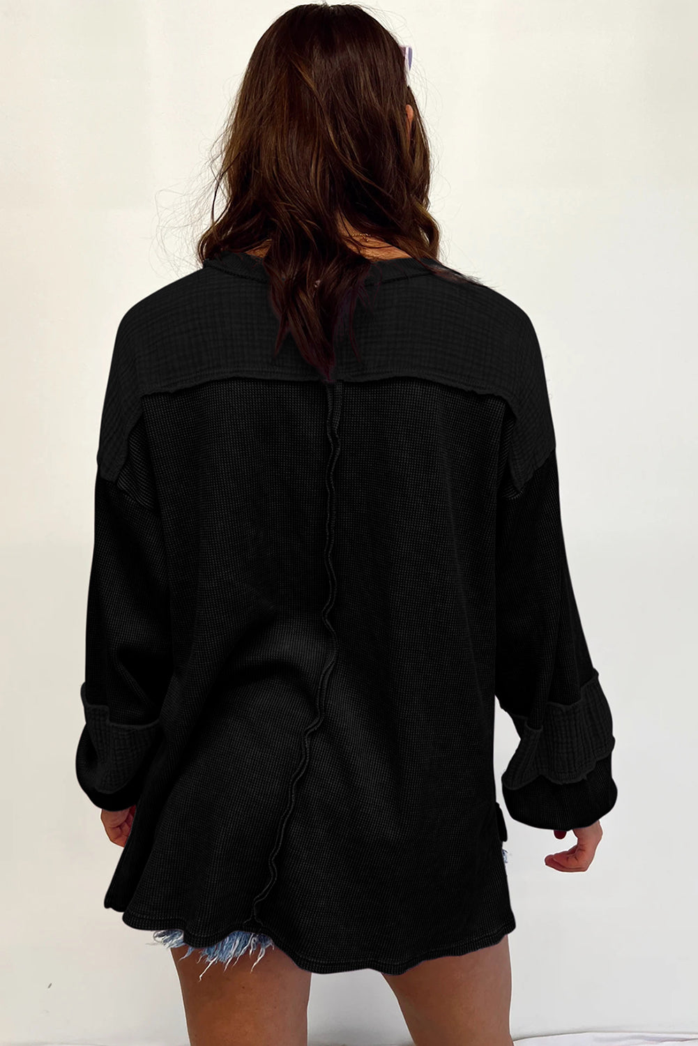 Dark brown waffle knit top with exposed seams and bubble sleeves, featuring a chic patchwork design and front pocket.