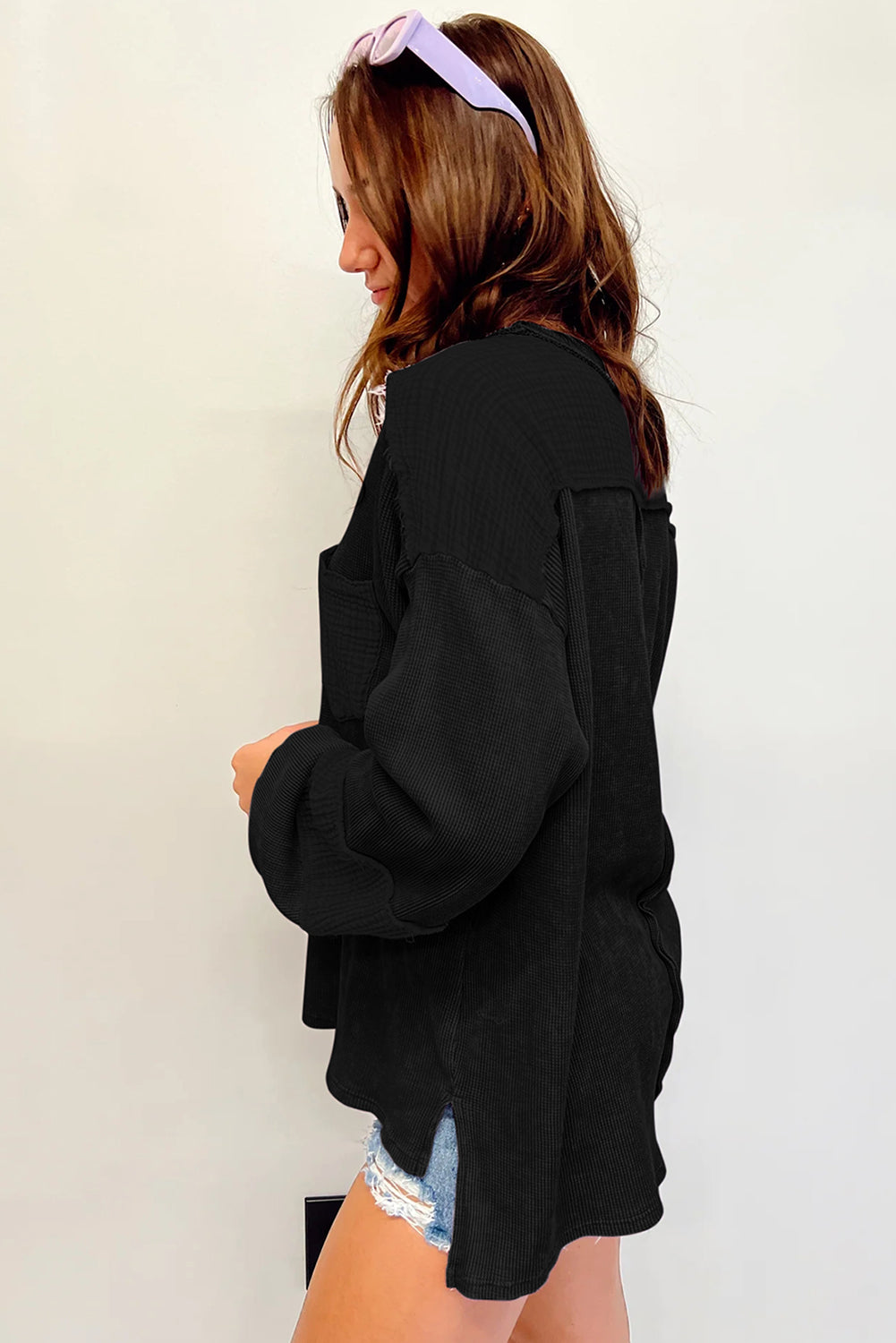 Dark brown waffle knit top with exposed seams and bubble sleeves, featuring a chic patchwork design and front pocket.