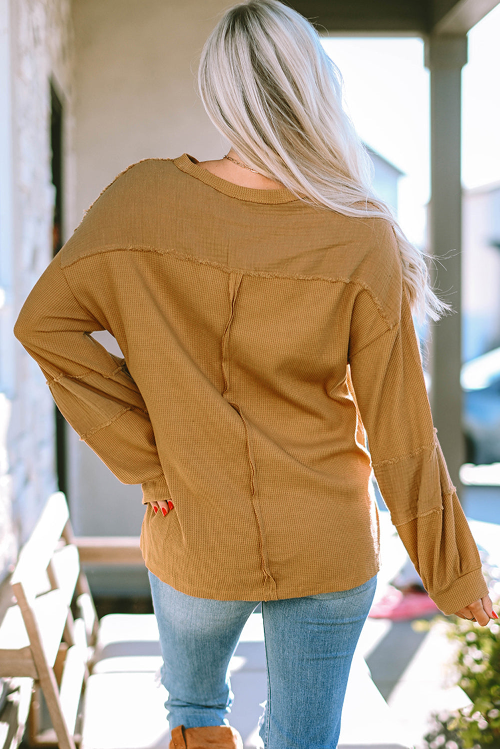 Dark brown waffle knit top with exposed seams and bubble sleeves, featuring a chic patchwork design and front pocket.