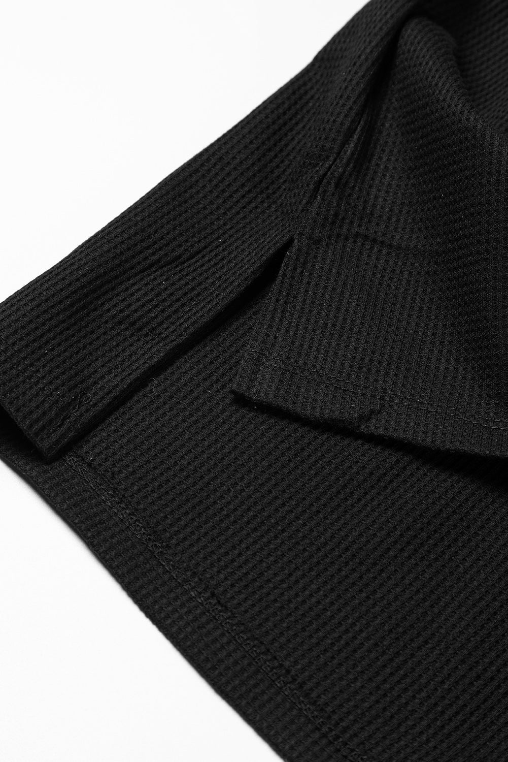 Dark brown waffle knit top with exposed seams and bubble sleeves, featuring a chic patchwork design and front pocket.