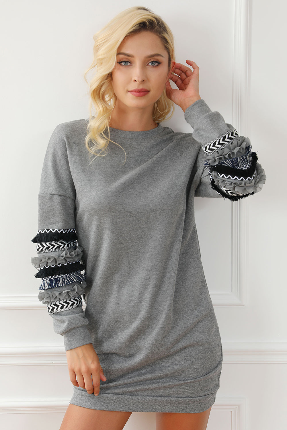 Dark grey sweatshirt dress featuring fringed and ruffled accents on sleeves, perfect for winter fashion.