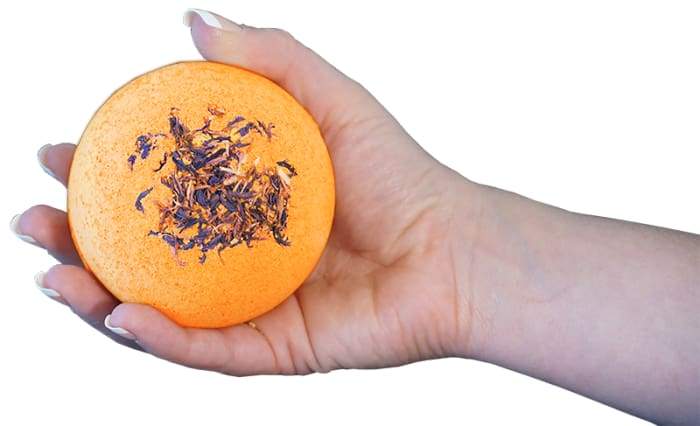 Energy - Bomb Core bath product featuring vibrant colors and essential oils, with a goat milk soap ball inside.