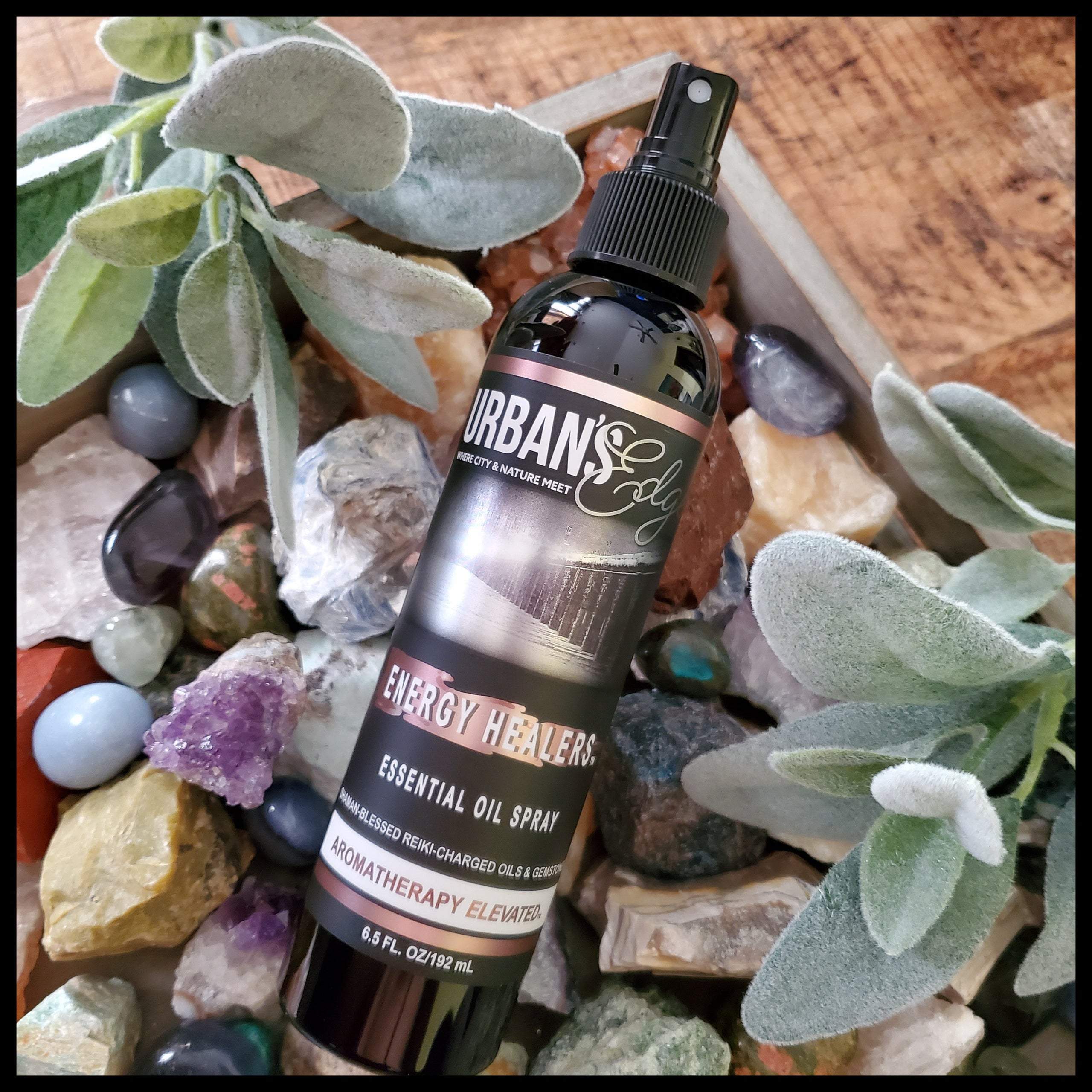 A bottle of ENERGY HEALERS Essential Oil Spray with a calming design, featuring essential oils and gemstones for energy cleansing.