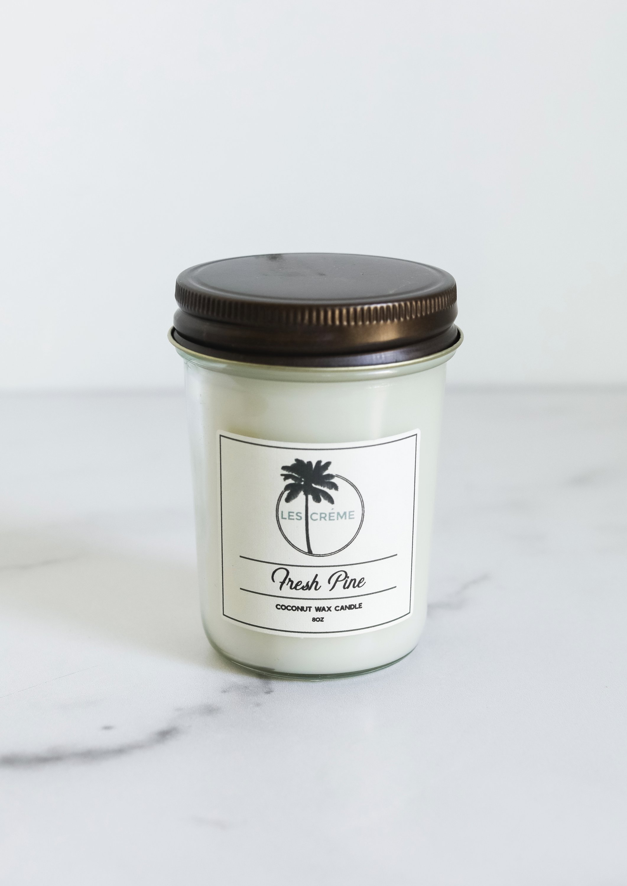 Fresh Pine Scent Coconut Wax Candle in a glass jar, showcasing its natural ingredients and inviting aroma.