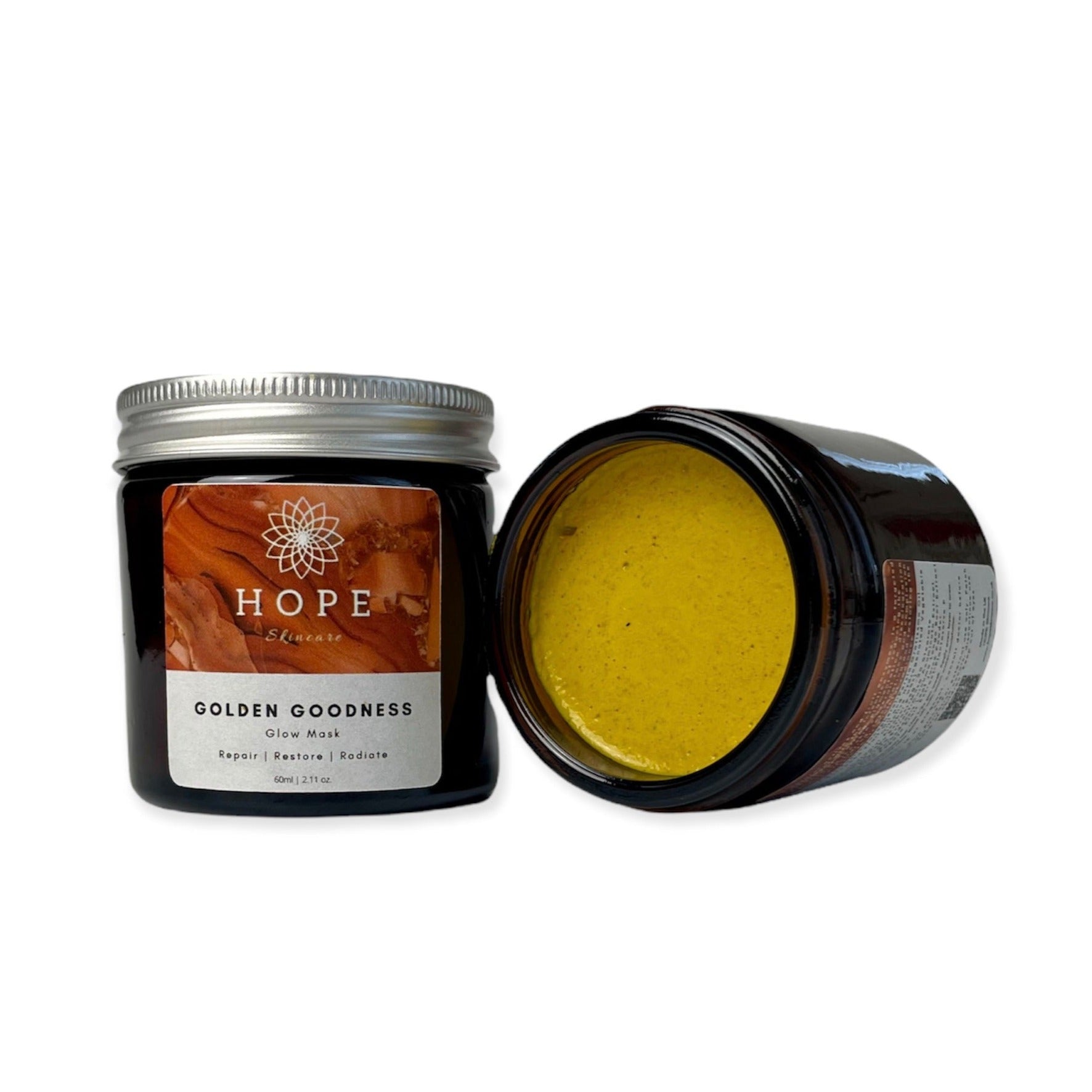 Golden Goodness Glow Mask in a sleek jar, showcasing its rich, creamy texture, surrounded by natural ingredients like pumpkin and papaya.