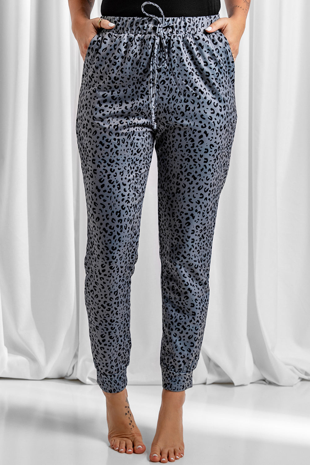 Gray joggers featuring a stylish leopard print design with a self-tie adjustable smocked waist for a comfortable fit.